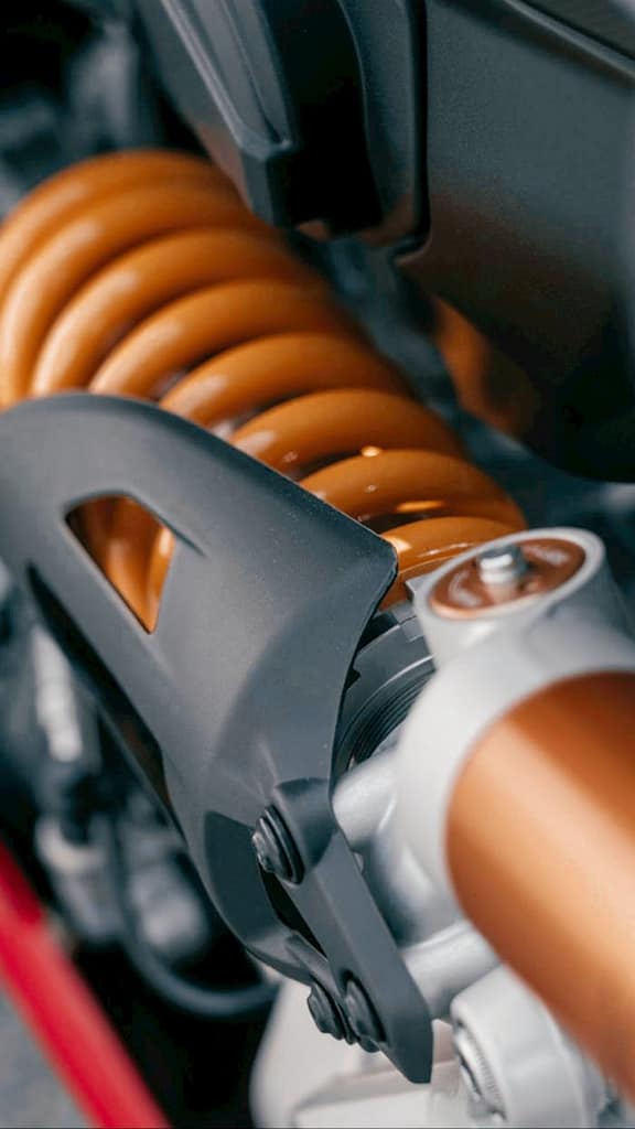 Mastering the First Impression: Your intriguing post title goes here Detailed view of a motorcycle shock absorber with orange coil spring.