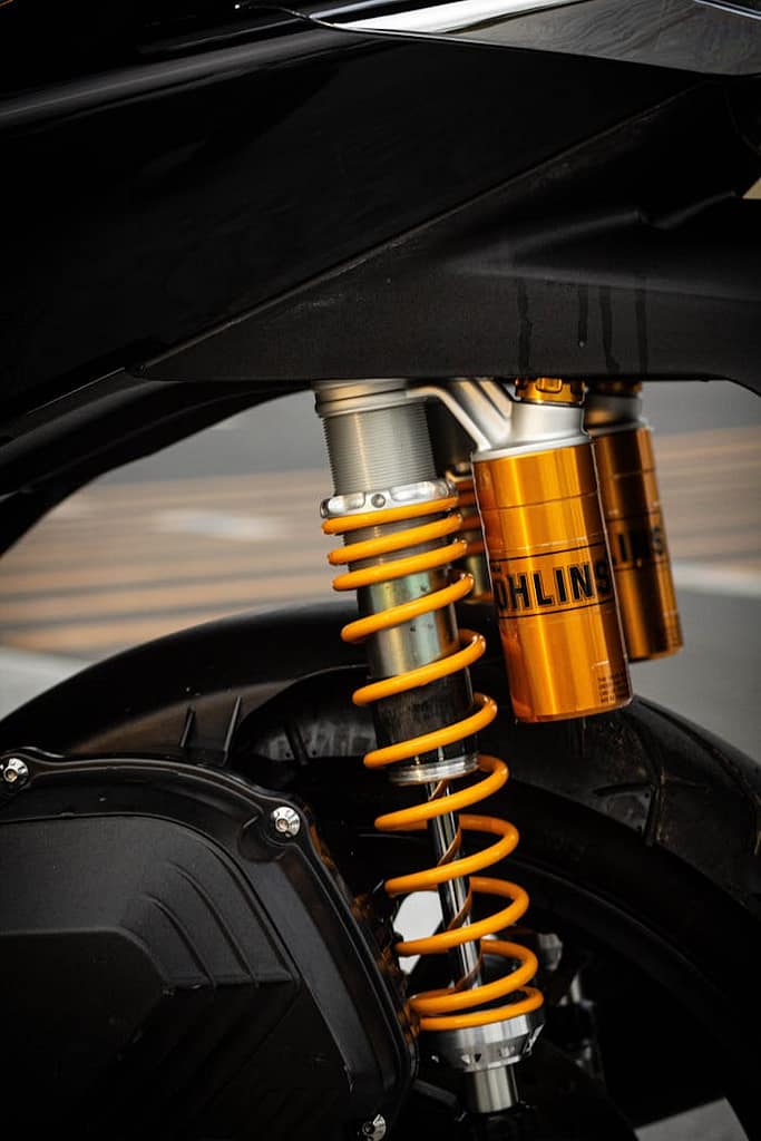 The Art of Drawing Readers In: Your attractive post title goes here Detailed view of a modern motorcycle suspension with Öhlins shocks.